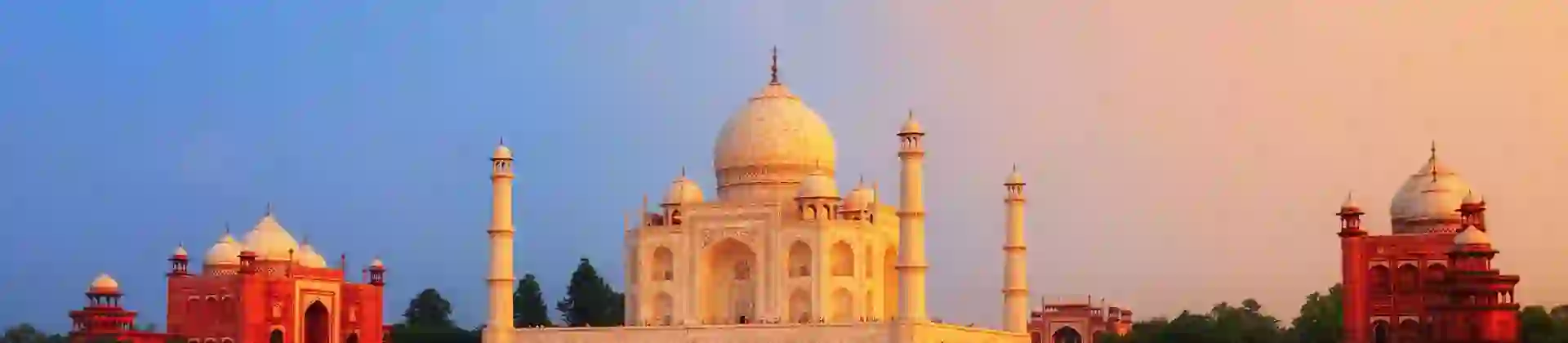 The Taj Mahal in Agra reflected in the calm waters of the Yamuna River at sunset