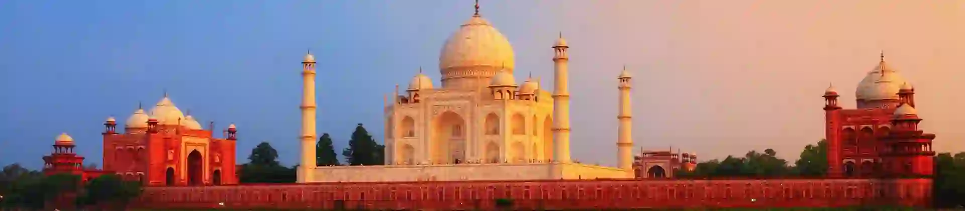 The Taj Mahal in Agra reflected in the calm waters of the Yamuna River at sunset