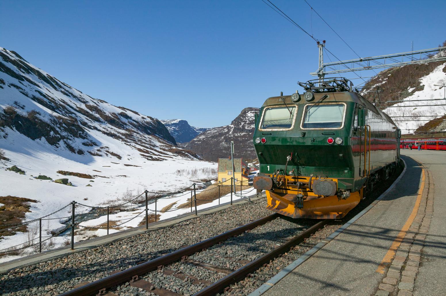 The Flåm Railway travelling through Norway's snowy mountains