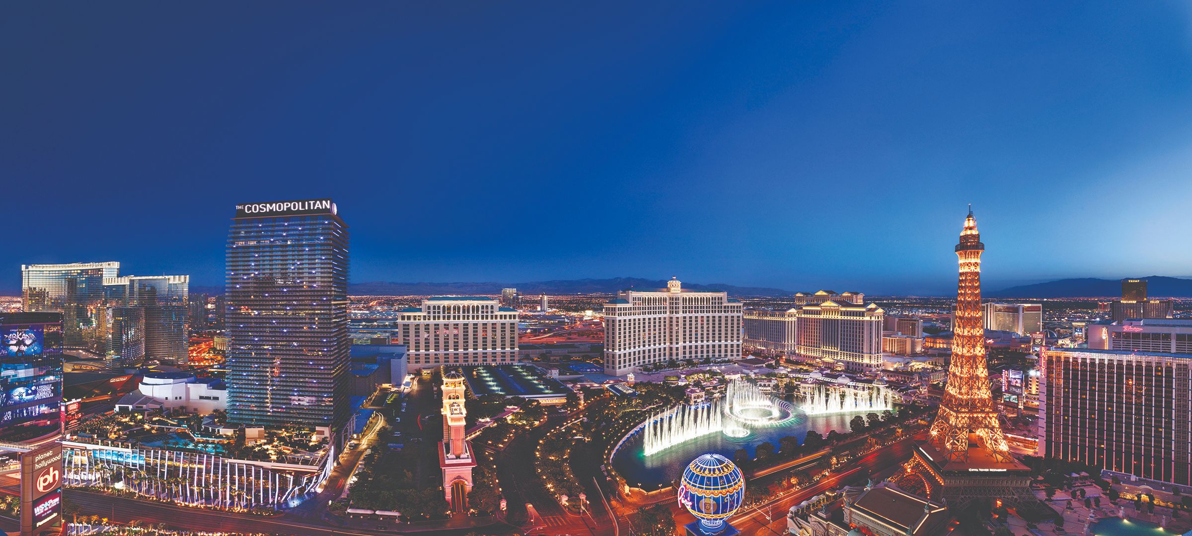 Aerial view of Las Vegas at night, with a dazzling display of colourful neon lights, illuminated streets, and iconic casinos glowing against the dark sky