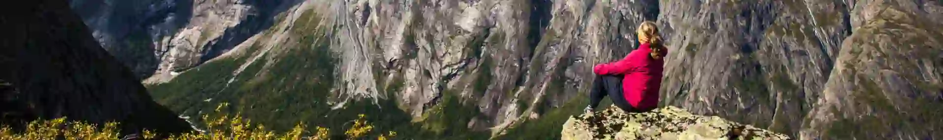 Solo woman traveller enjoying the views of the famous Troll Wall, Fjord Norway