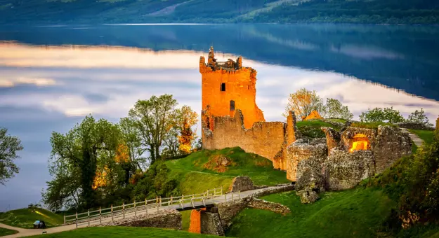 View of Urquhart Castle and Loch Ness, with the sun shining on the castle