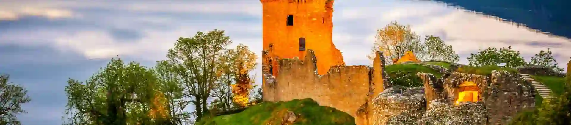 View of Urquhart Castle and Loch Ness, with the sun shining on the castle