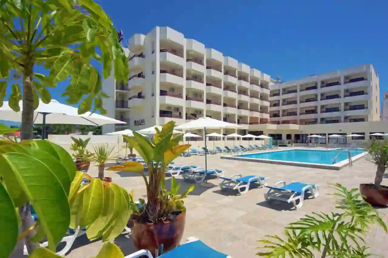 Outdoor pool at Hotel Alba in Portugal, surrounded by hotel room balconies, with sunloungers arranged around the poolside