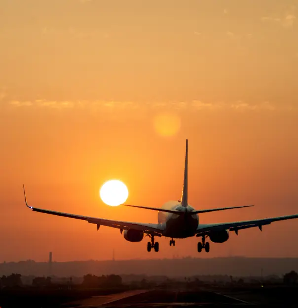 Airplane landing at sunset 