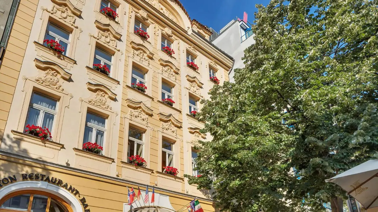 Façade of Hotel Adria in Prague with flower-adorned windows and ornate details