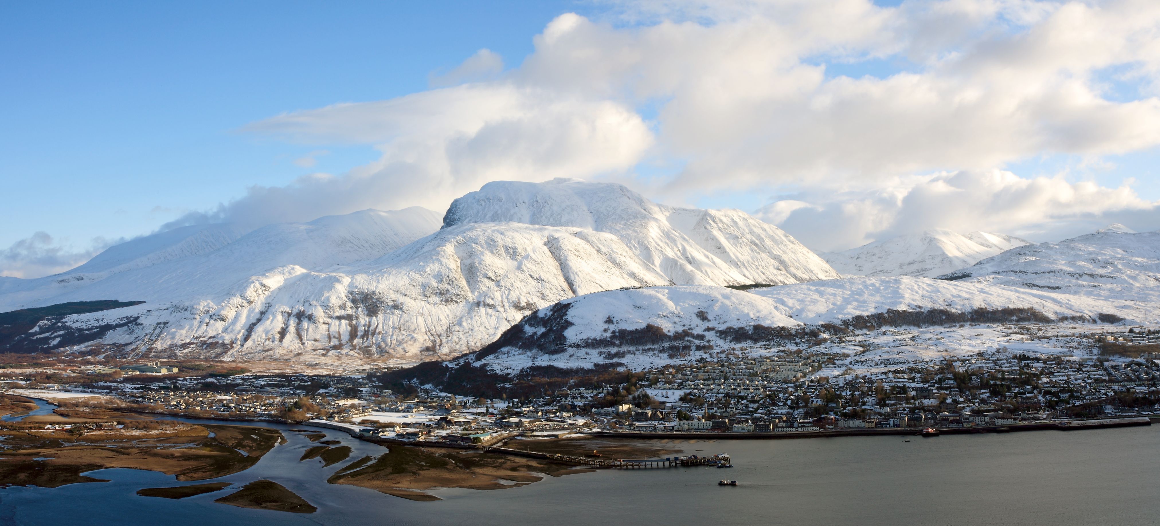 View of Fort William village with snowy Ben Nevis mountain behind 