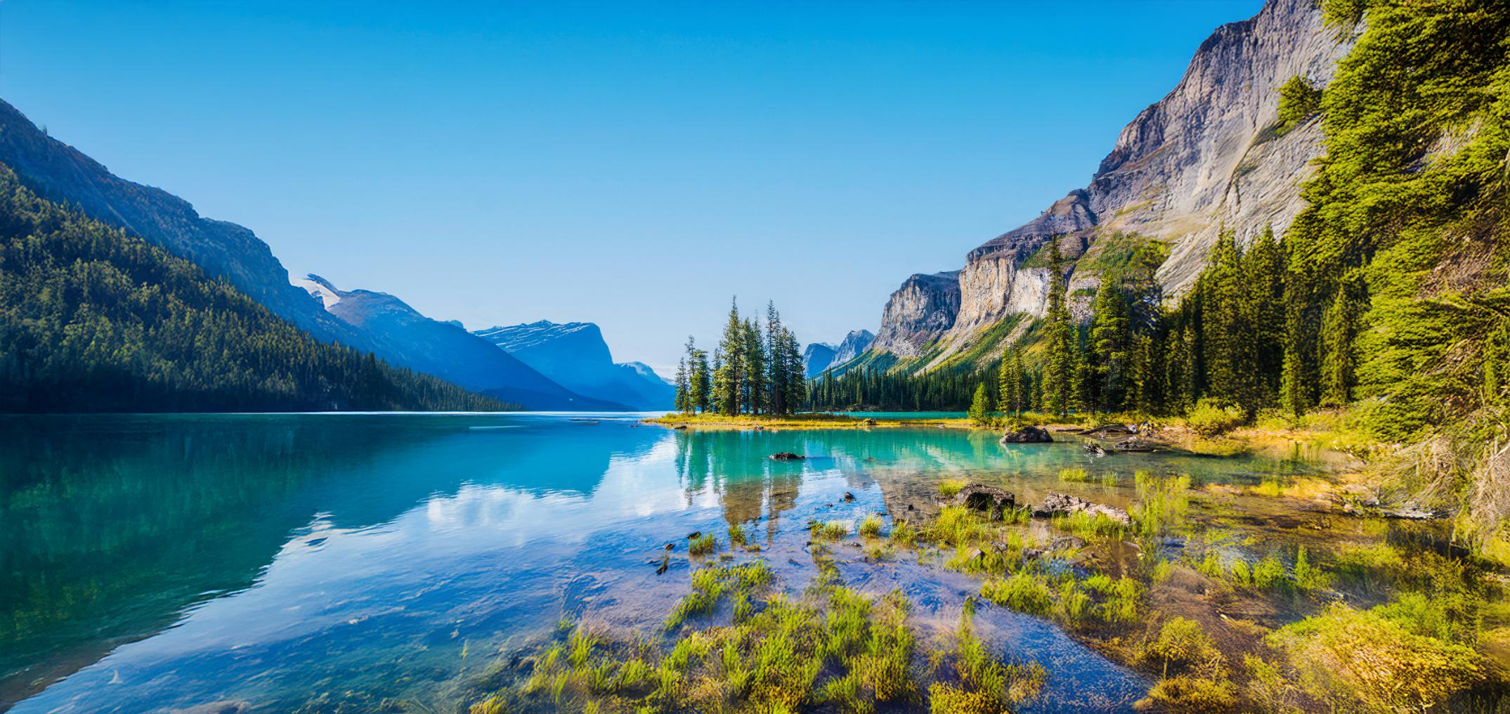 Lake Moraine in Canada with turquoise waters, surrounded by pine forests and towering Rocky Mountains