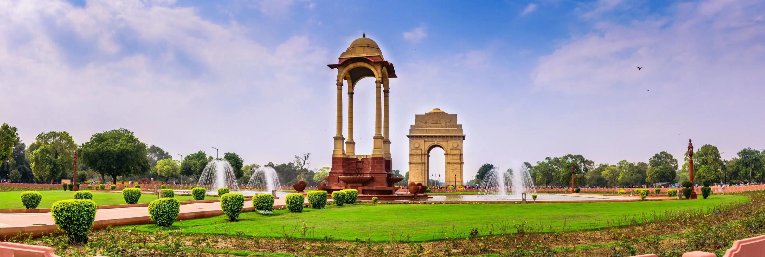 A view of India Gate and surrounding fountains and gardens in Delhi, India