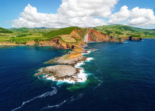 Green hills and volcanic landscapes of the Azores, with the Atlantic Ocean in the foreground