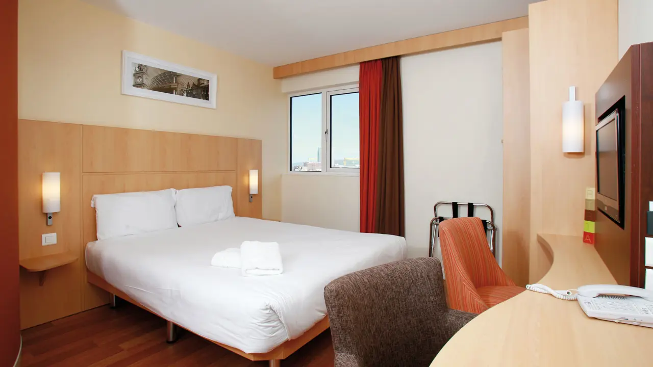Bright and modern hotel room at the Ibis Belfast City Centre, with a double bed, desk, and city view through the window