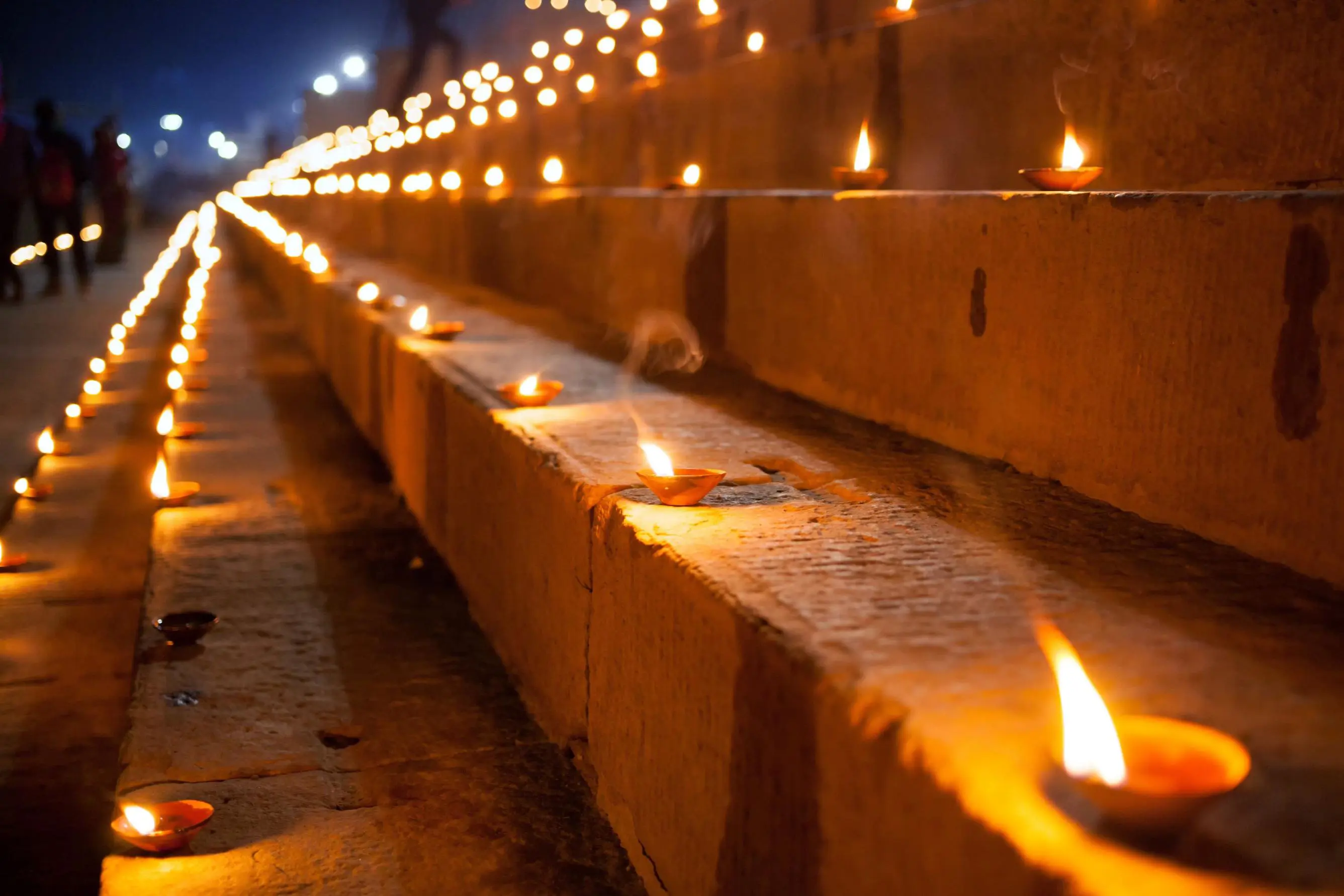 Rows of glowing tealights illuminating stone steps at night during Diwali