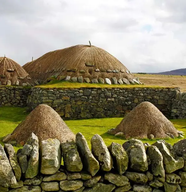 Arnol Black House, with mounds of hay surrounded by a stone wall in the forefront