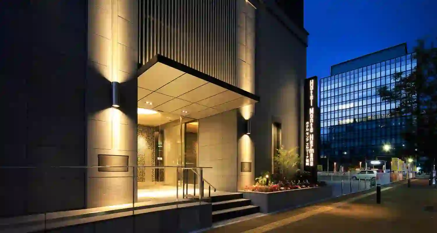 Exterior of Hotel Monte Hermana in Fukuoka, a modern high-rise building with a sleek façade and large windows, set in an urban cityscape
