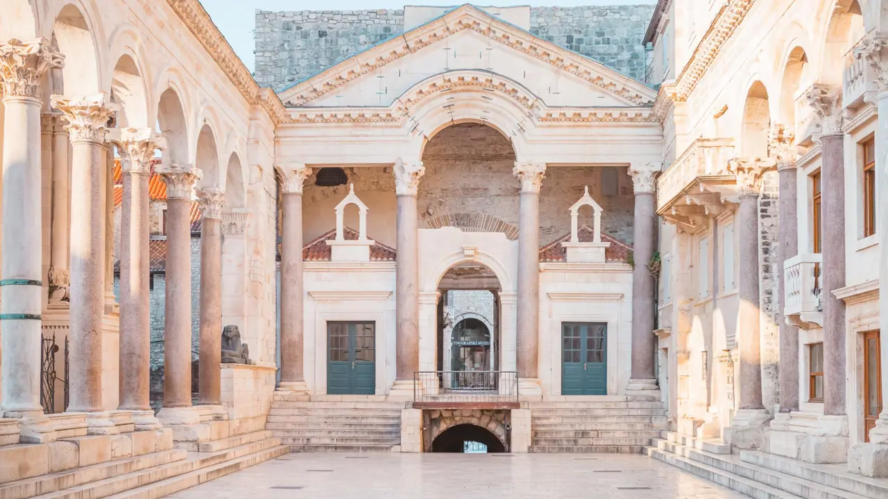 Interior courtyard of Diocletian’s Palace in Split, Croatia, featuring Roman columns, arches, and stone steps bathed in soft morning light