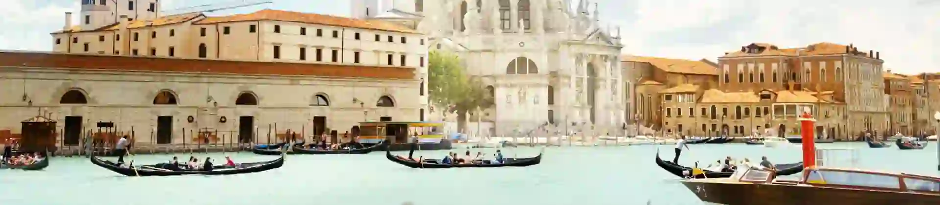 View of gondola boats travelling on the water and the Salute Church in Venice, Italy
