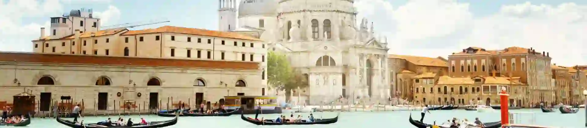 View of gondola boats travelling on the water and the Salute Church in Venice, Italy