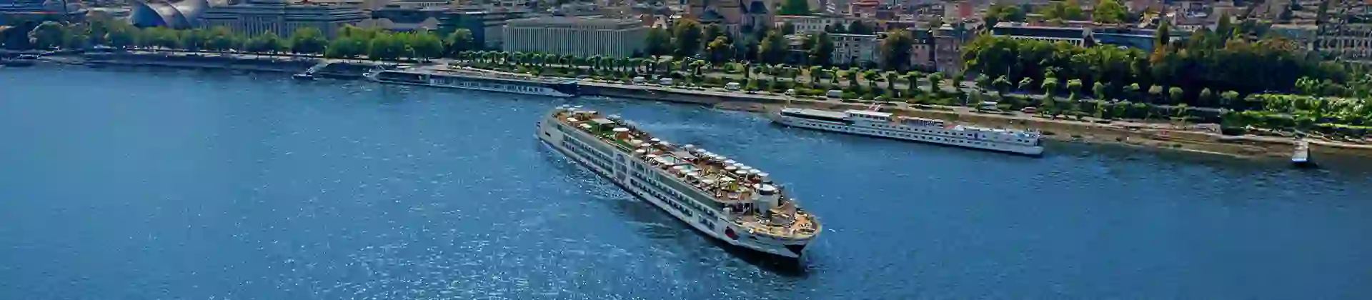 A-ROSA river cruise ship sailing on the Rhine River with Cologne Cathedral and city skyline in the background