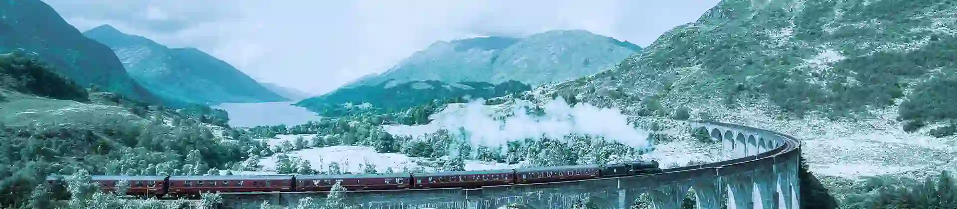 Train going along a viaduct in the snow in the Highlands