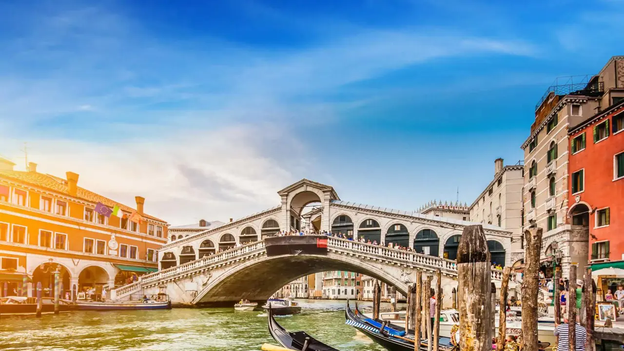 Rialto Bridge, Venice, Italy, with gondola boats in the forefront 
