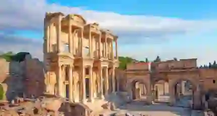 Ancient ruins of the Library of Celsus in Ephesus, Turkey, with a clear sky and warm sunlight highlighting the detailed stone architecture