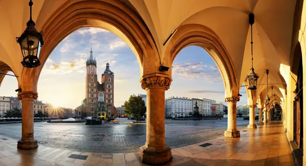 View of St. Mary's Basilica from the arches of the Cloth Hall in Kraków’s main square at sunrise