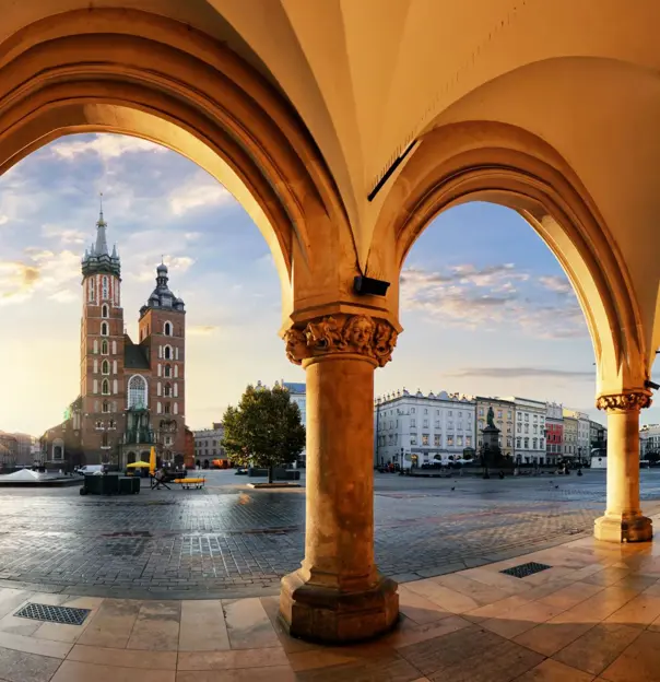 View of St. Mary's Basilica from the arches of the Cloth Hall in Kraków’s main square at sunrise