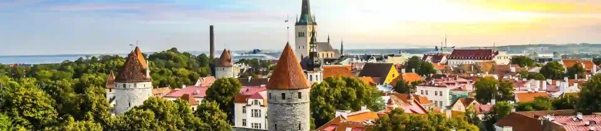 Medieval towers and colourful rooftops in the old town of Tallinn, with a church spire in the background