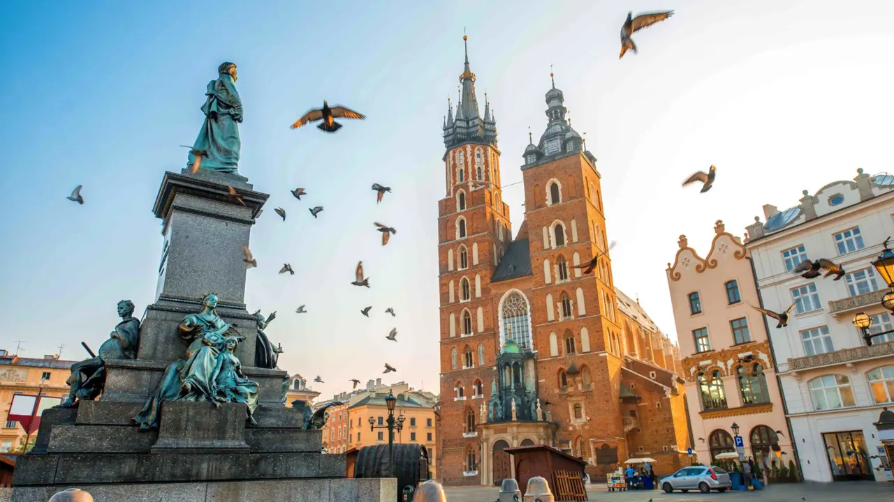 The Main Square in Kraków, Poland, with historic buildings and St. Mary's Basilica in the background