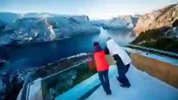 Two people looking out over a fjord in the snow