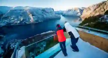 Two people looking out over a fjord in the snow
