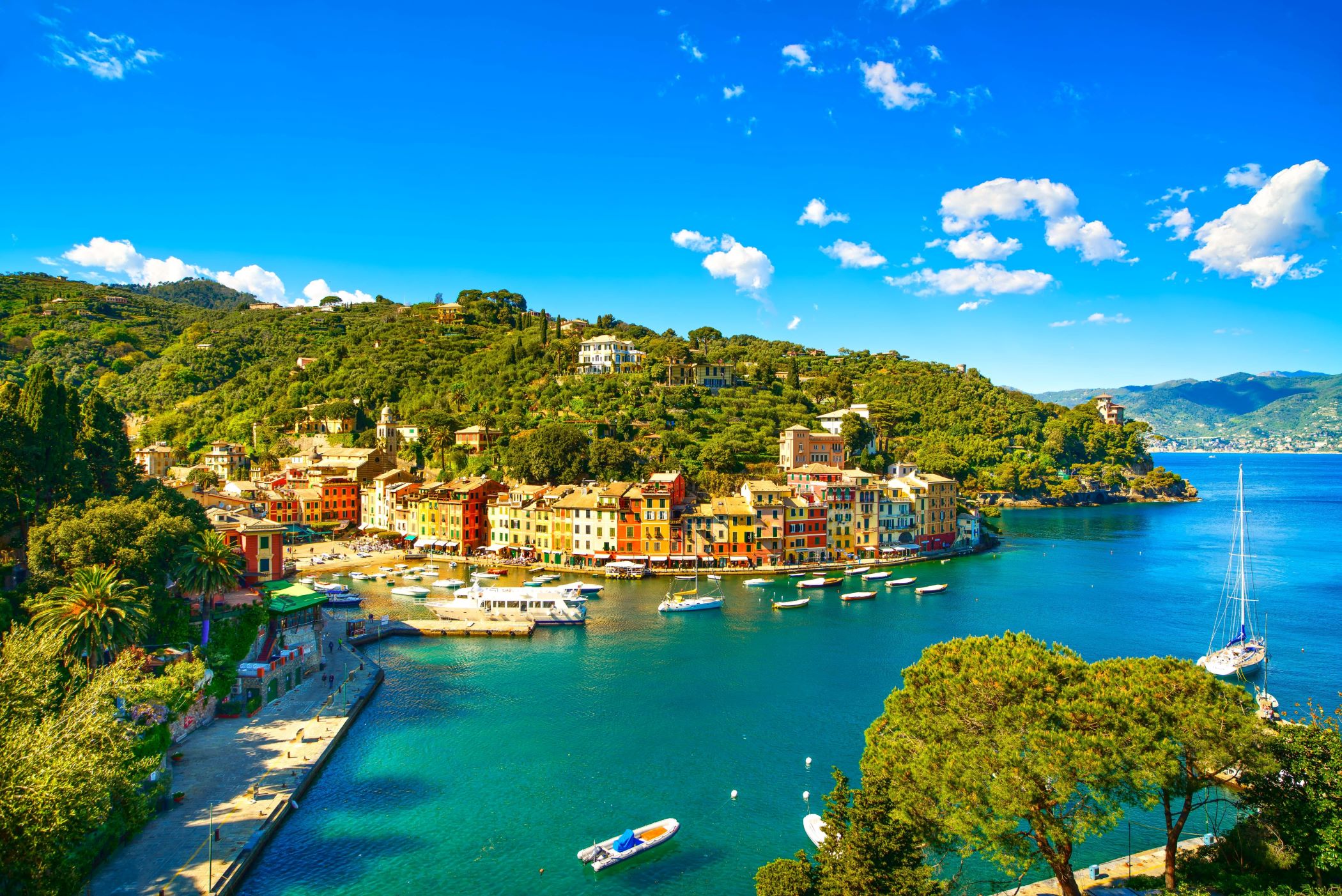 View of a small beach in Portofino, showing boats on the water and buildings on the waterfront