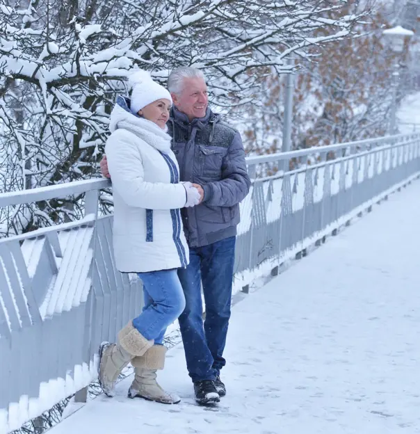 Sh_773598061 Senior mature couple in winter snow on a bridge