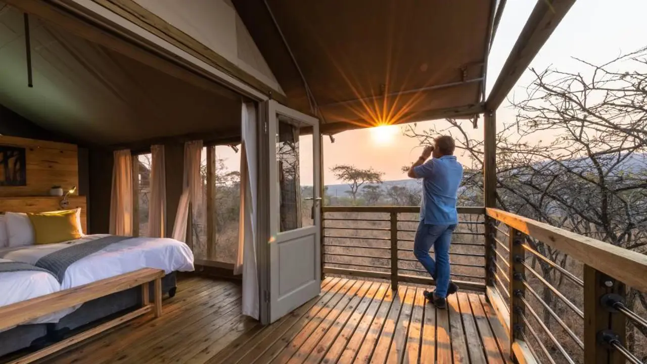 Ndhula Luxury Tented Lodge, Kruger, guest on the tent balcony