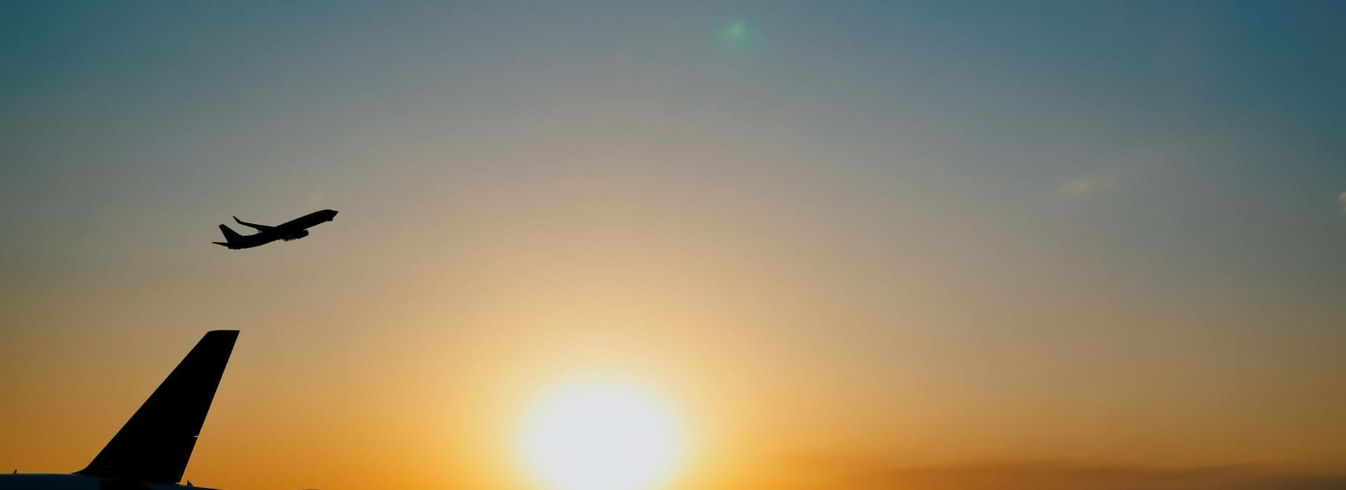 Airplane taking off at sunset over an airport 