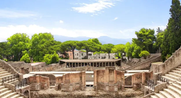 The theatre district in Pompeii with the ancient theatre in the foreground and the Quadriporticus - a large rectangular courtyard surrounded by covered walkways visible behind it