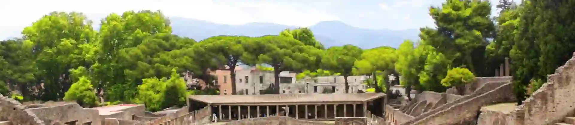 The theatre district in Pompeii with the ancient theatre in the foreground and the Quadriporticus - a large rectangular courtyard surrounded by covered walkways visible behind it