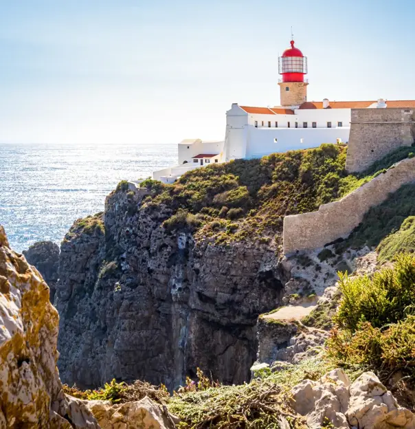 Rocky landscape at Cape St. Vincent on the Algarve, with the lighthouse visible in the distance.