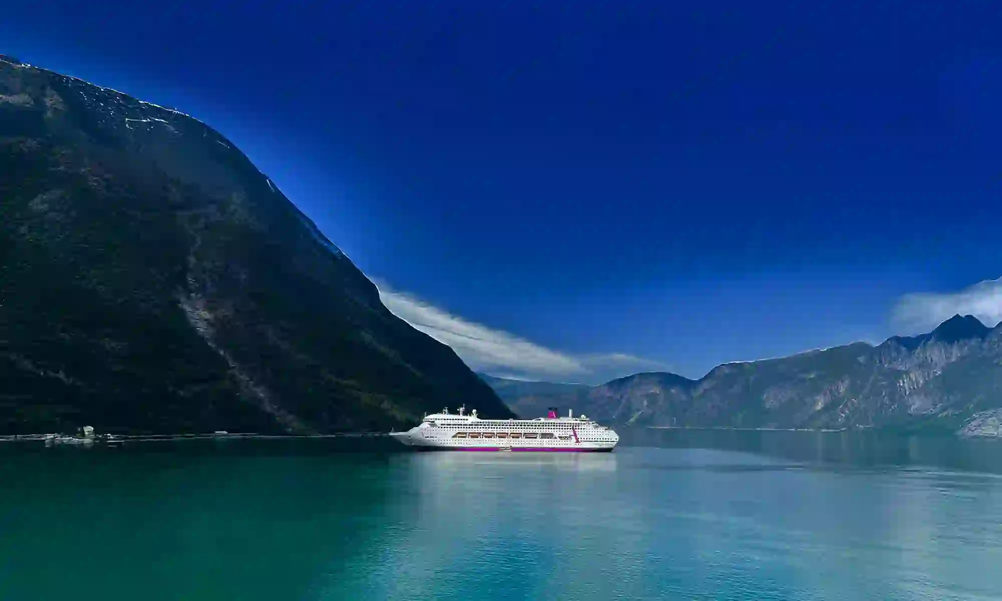 An Ambassador Cruise Line ship sailing in calm waters near Eidfjord in Norway