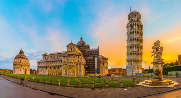 View of the Tower of Pisa and surrounding monuments at sunset