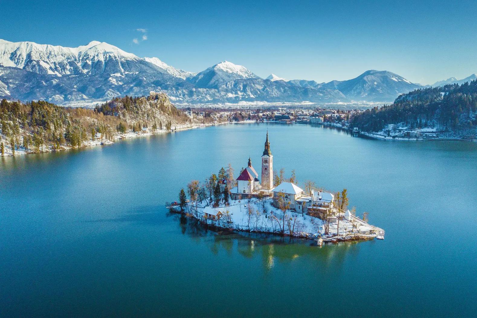 Lake Bled in winter with its island church in the centre and frosty mountains in the background